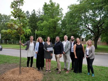 Groupe de personnes posant devant le chêne blanc planté pour souligner les 25 ans du programme.